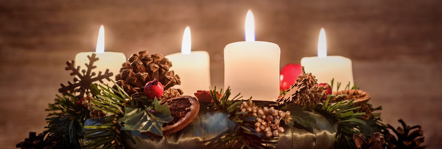 Adventskranz mit vier brennenden Kerzen