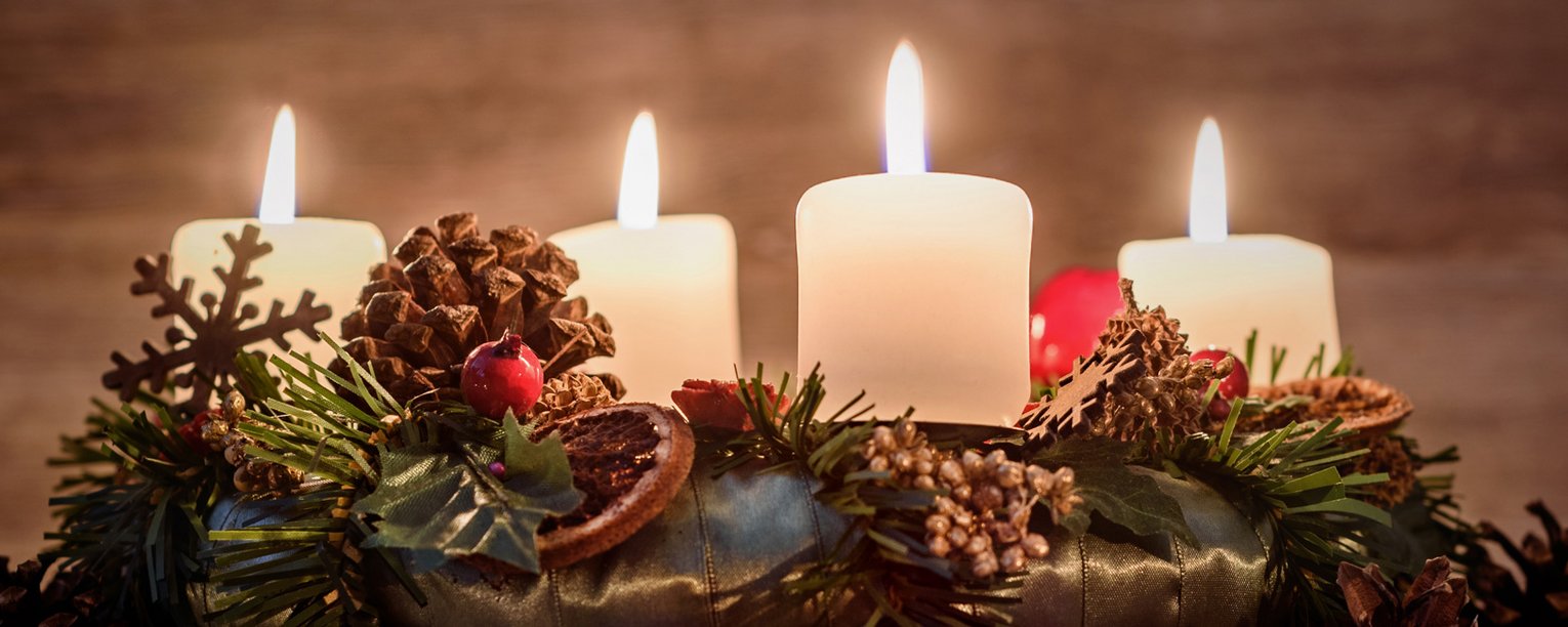 Adventskranz mit vier brennenden Kerzen