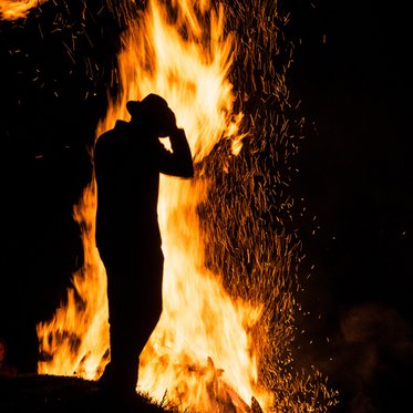 Person vorm Sonnenwendfeuer in Gastein