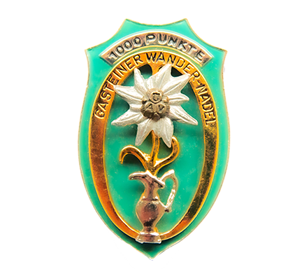 Eine Wandernadel mit einem Edelweiß darauf und dem Gasteiner Krug