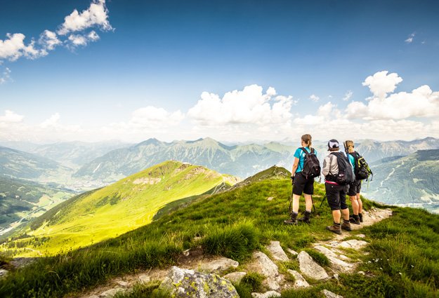 Drei Wanderer am Gipfel mit Blick über Gastein.