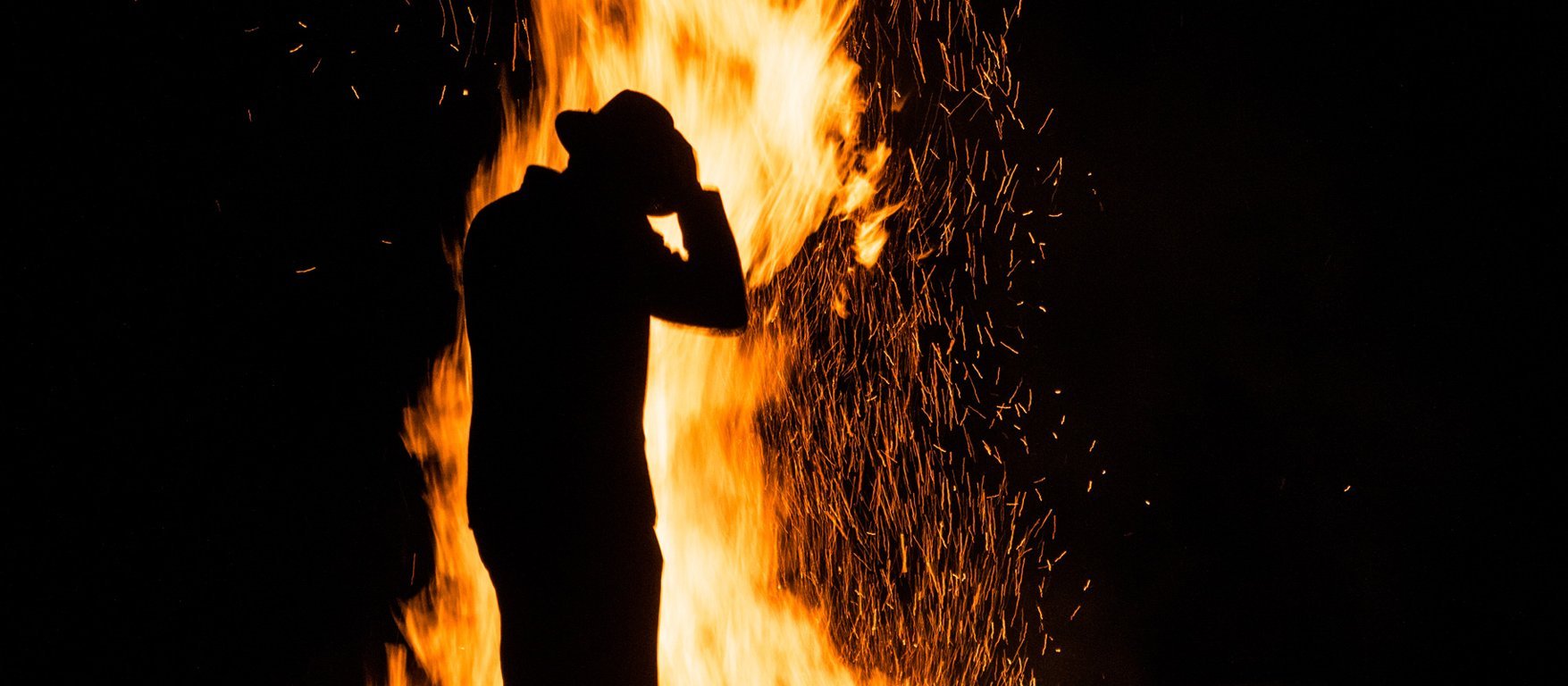 Person vorm Sonnenwendfeuer in Gastein