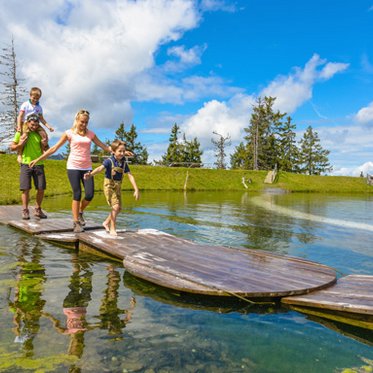Familie beim Wander auf dem Fulseck in Dorfgastein mit Blick auf den Bergsee