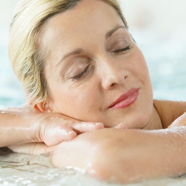 Dame beim Entspannen im Thermalwasserbecken in der Alpentherme Gastein